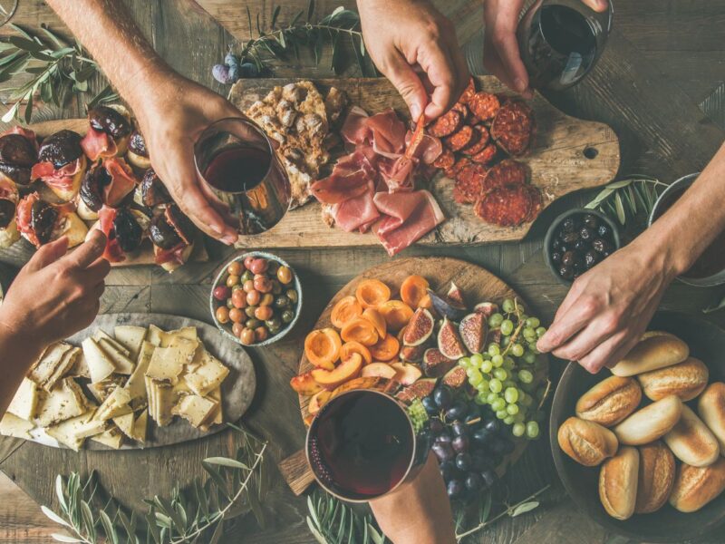 A well-stocked charcuterie board filled with meats, cheeses, and veggies.