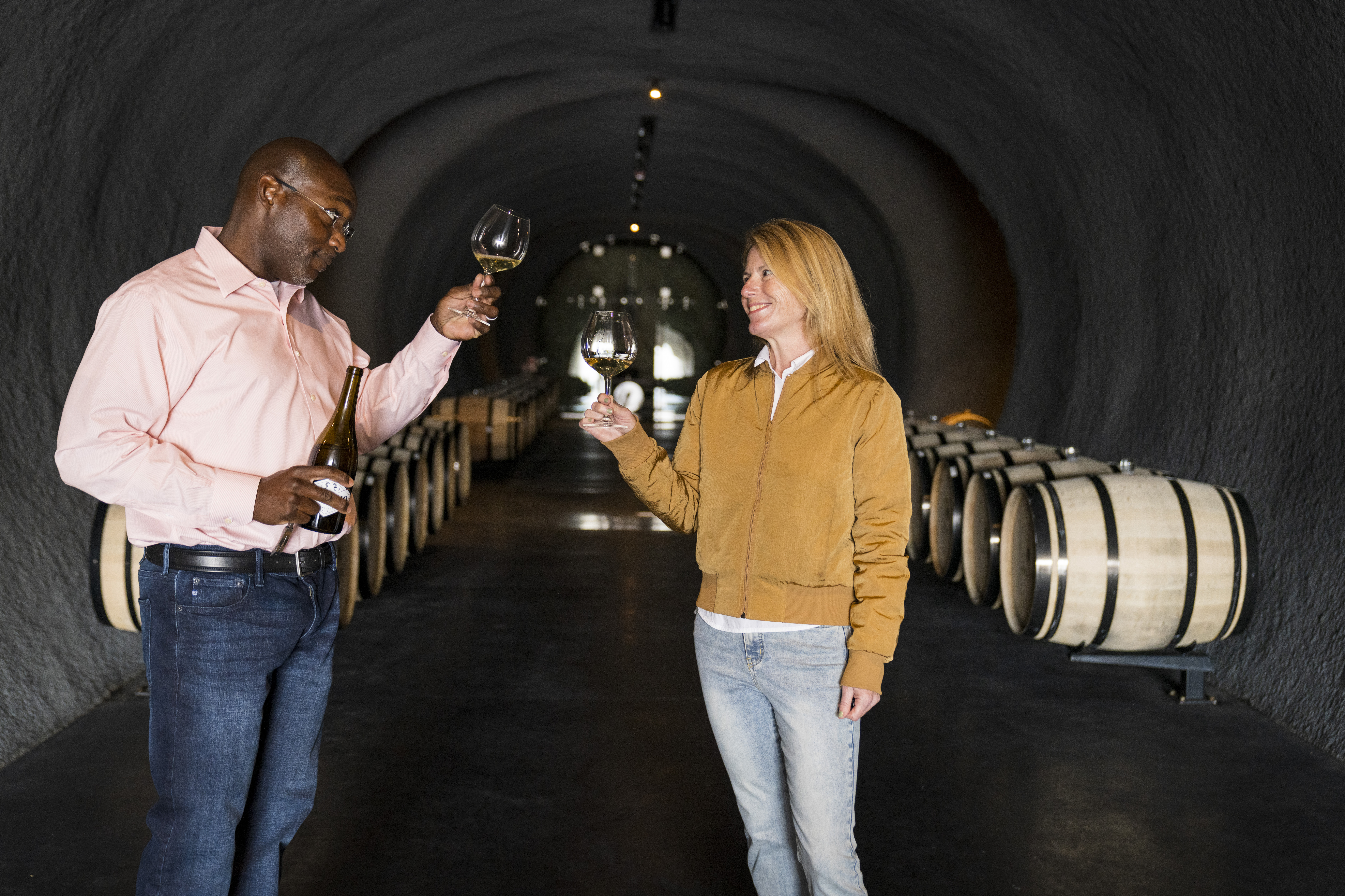 This is an image of female winemaker, Rachel Martin, founder of our California wine company, and Marbue Marke cheering/raising classes in winery. The image is shown in conjunction with our blog post about our socially responsible wine company and how it supports other women in need.