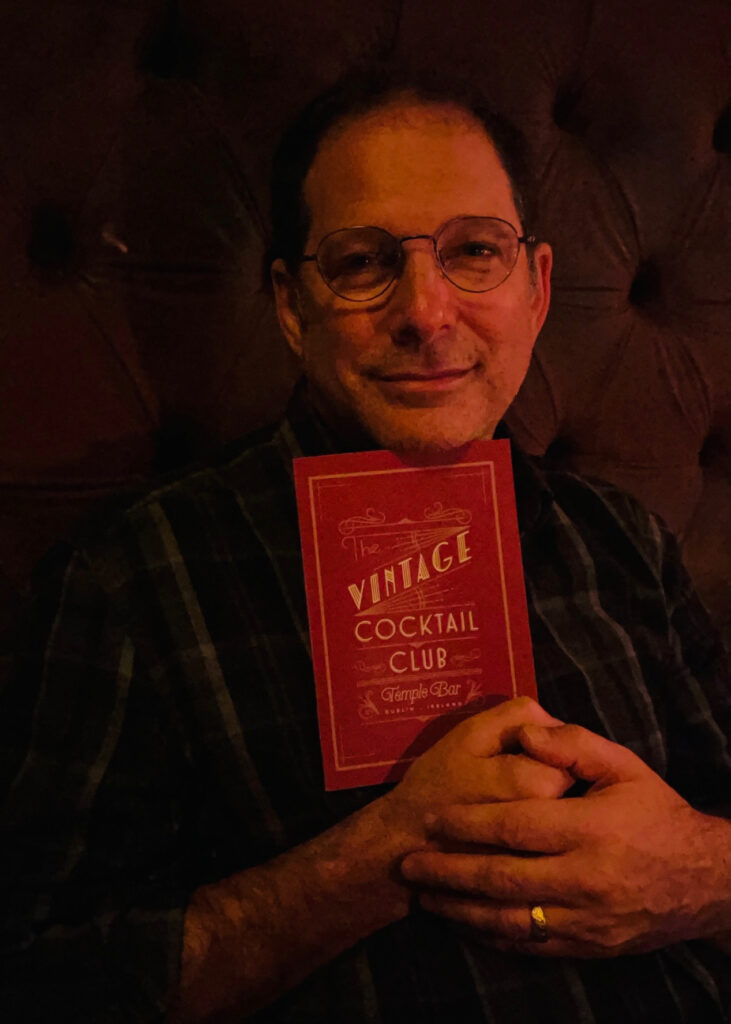 Kurt Deutsch holding menu of a vintage cocktail club