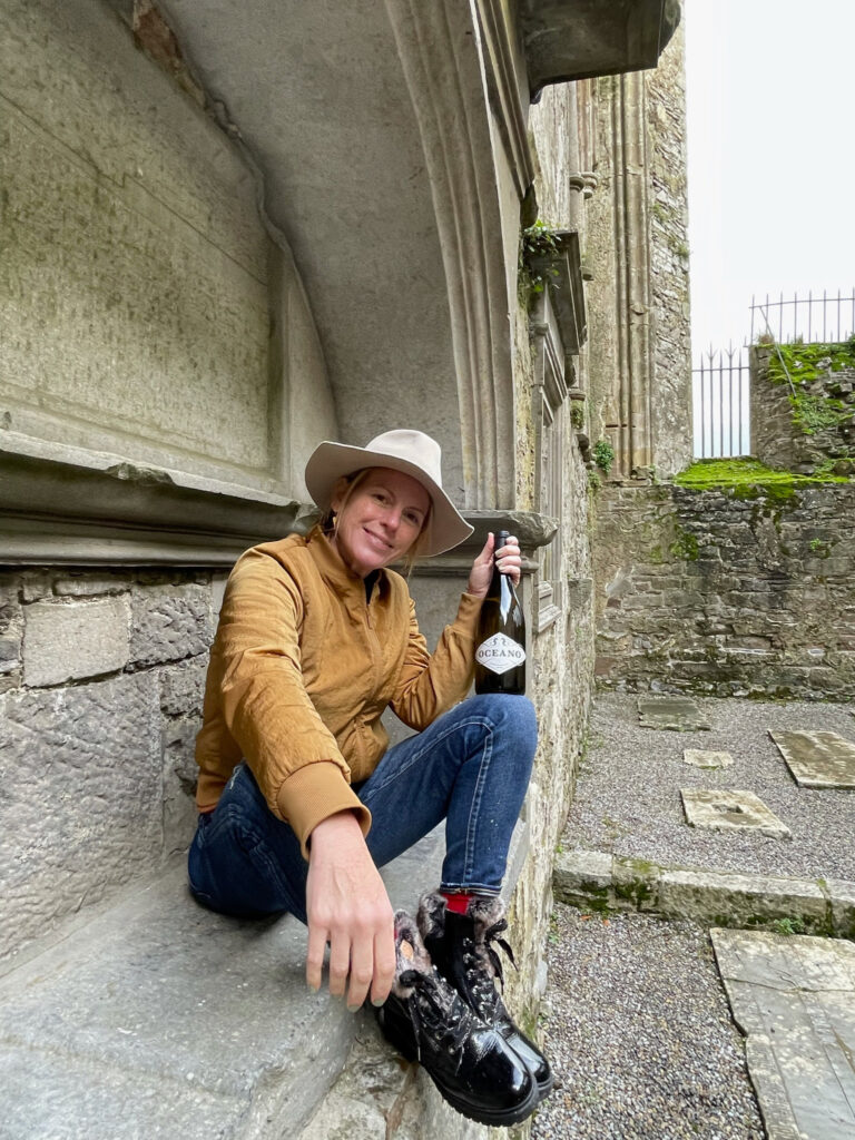 Rachel Martin sitting on ledge at the Rock of Cashel in Ireland