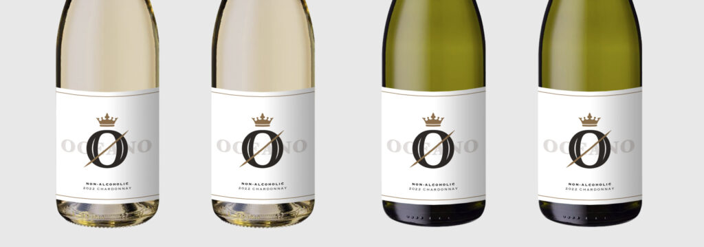 Image of four bottles of wine standing side by side - two show clear or lighter colored bottles that house white white, two show green, darker colored bottles that house red white. The bottoms have labels that show the new Oceano Zero brand of non-alcoholic wines, offered by our California winery and California wine company.
