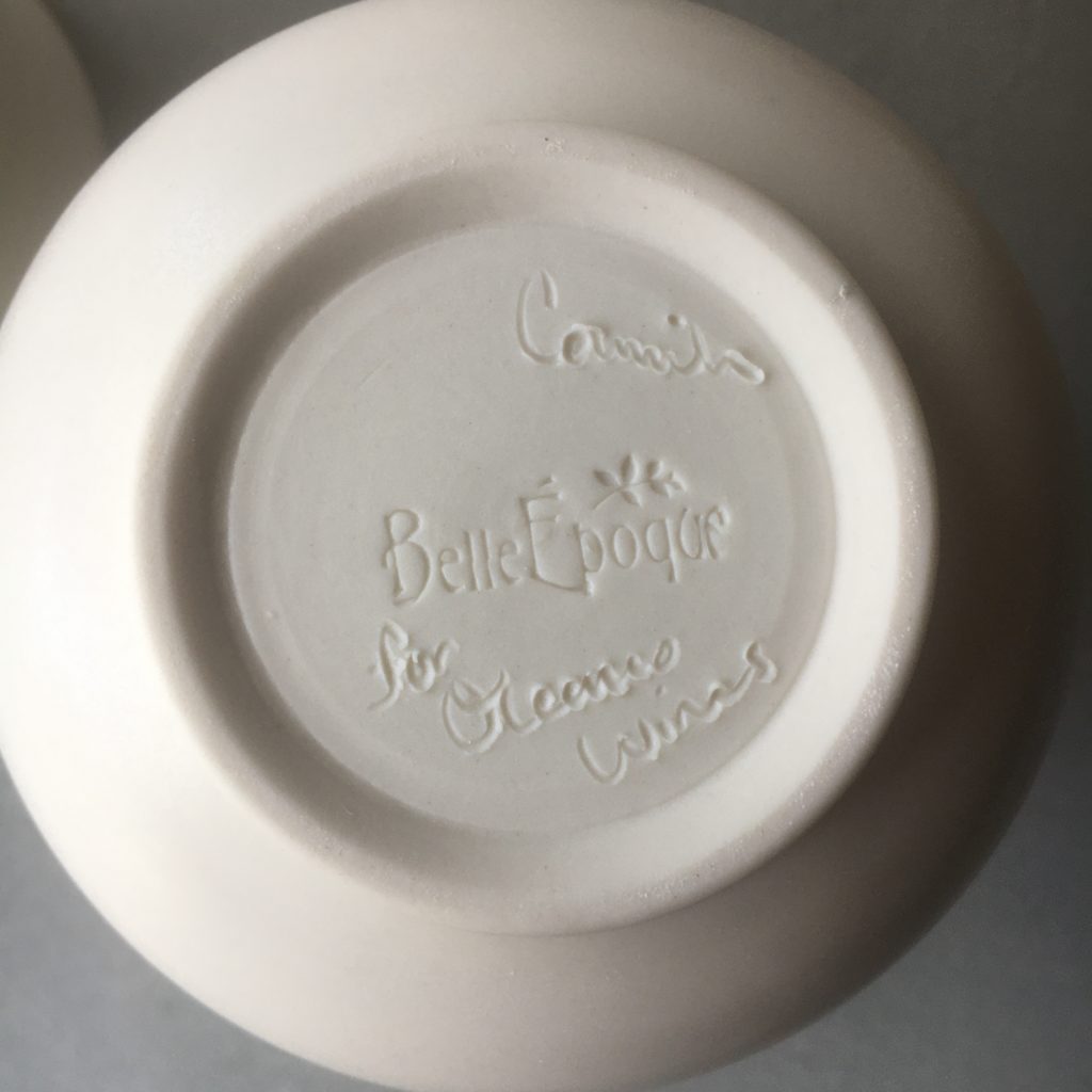 The base of a hand-crafted mug that has "Camila, for Oceano Wines" engraved in the bottom.