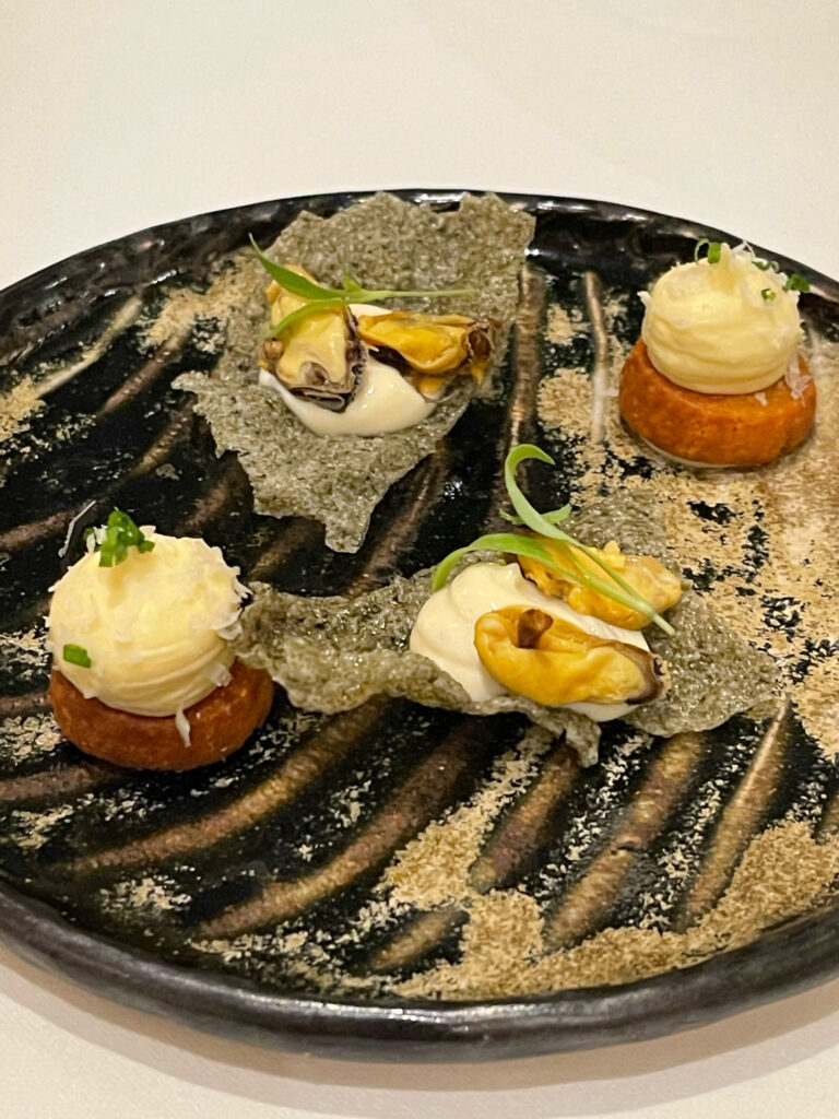 Food sits on top of a black plate with stripes on it.