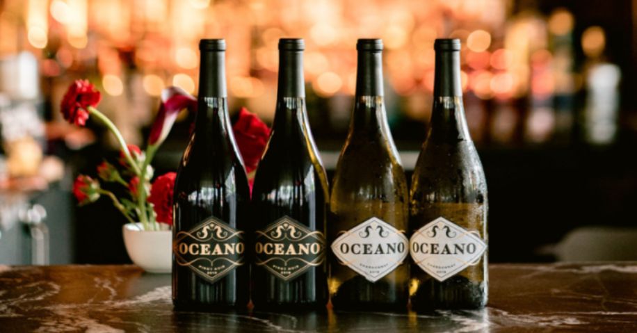 Four bottles of Oceano wine on the marble counter of a bar.