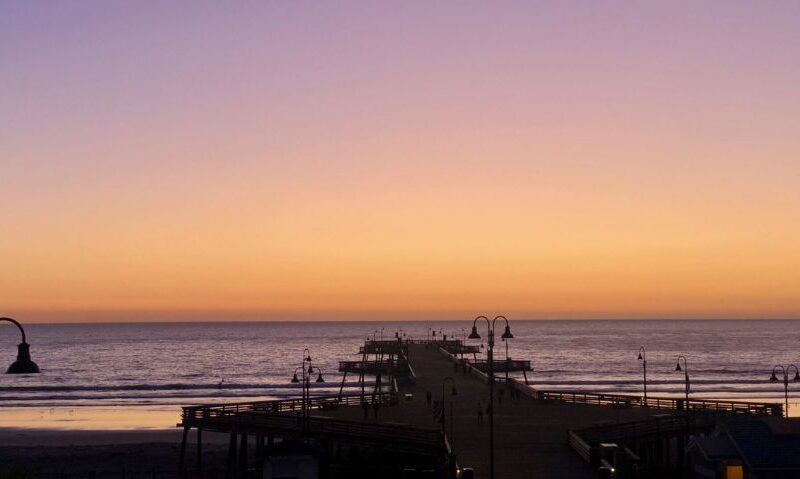 A pier overlooking the ocean at sunset.