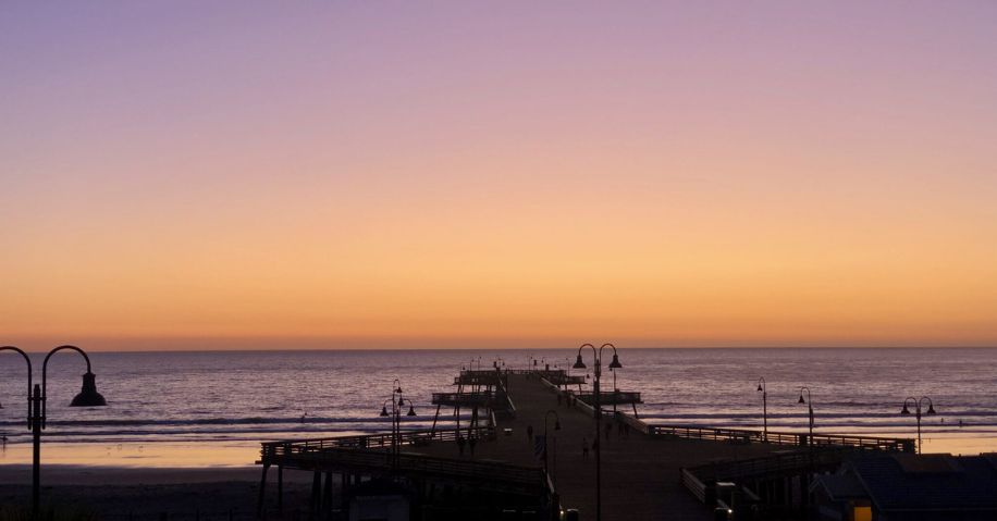 A pier overlooking the ocean at sunset.