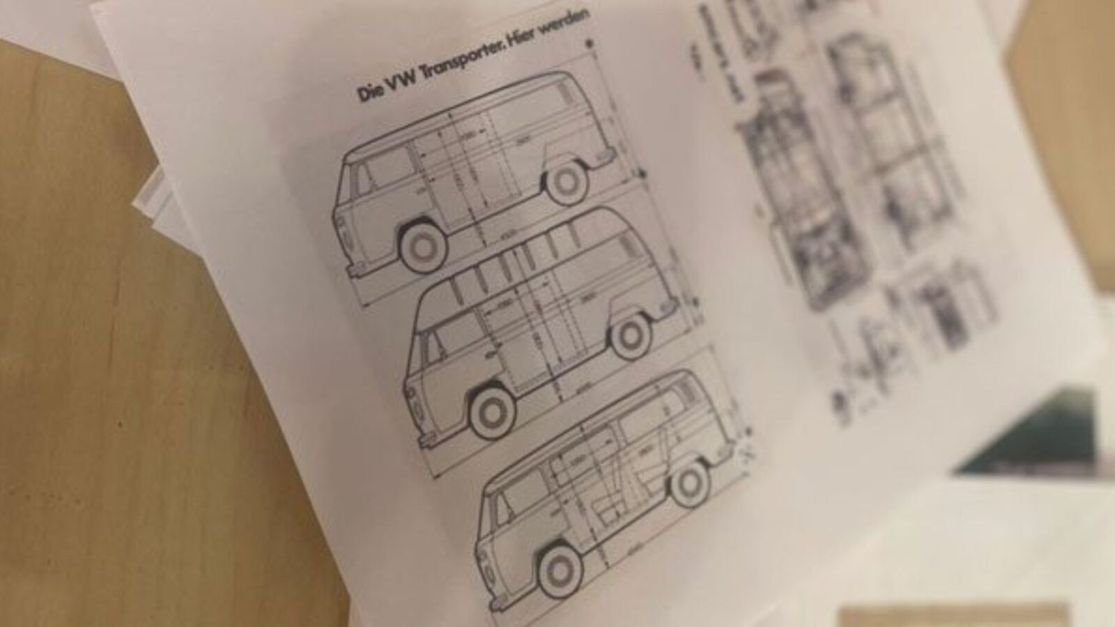 Drawings of a Volkswagen bus with measurements laying on a table.