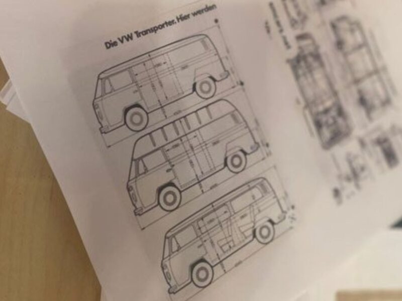 Drawings of a Volkswagen bus with measurements laying on a table.