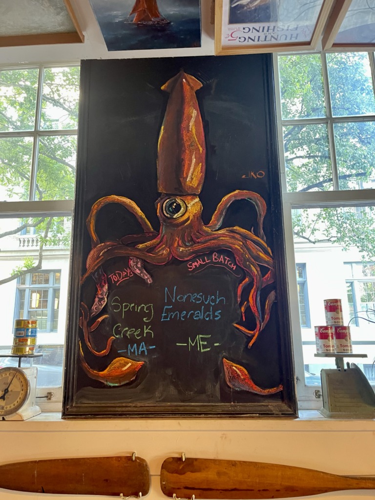 A beautifully illustrated drawing of a squid on a chalkboard in a seafood restaurant.