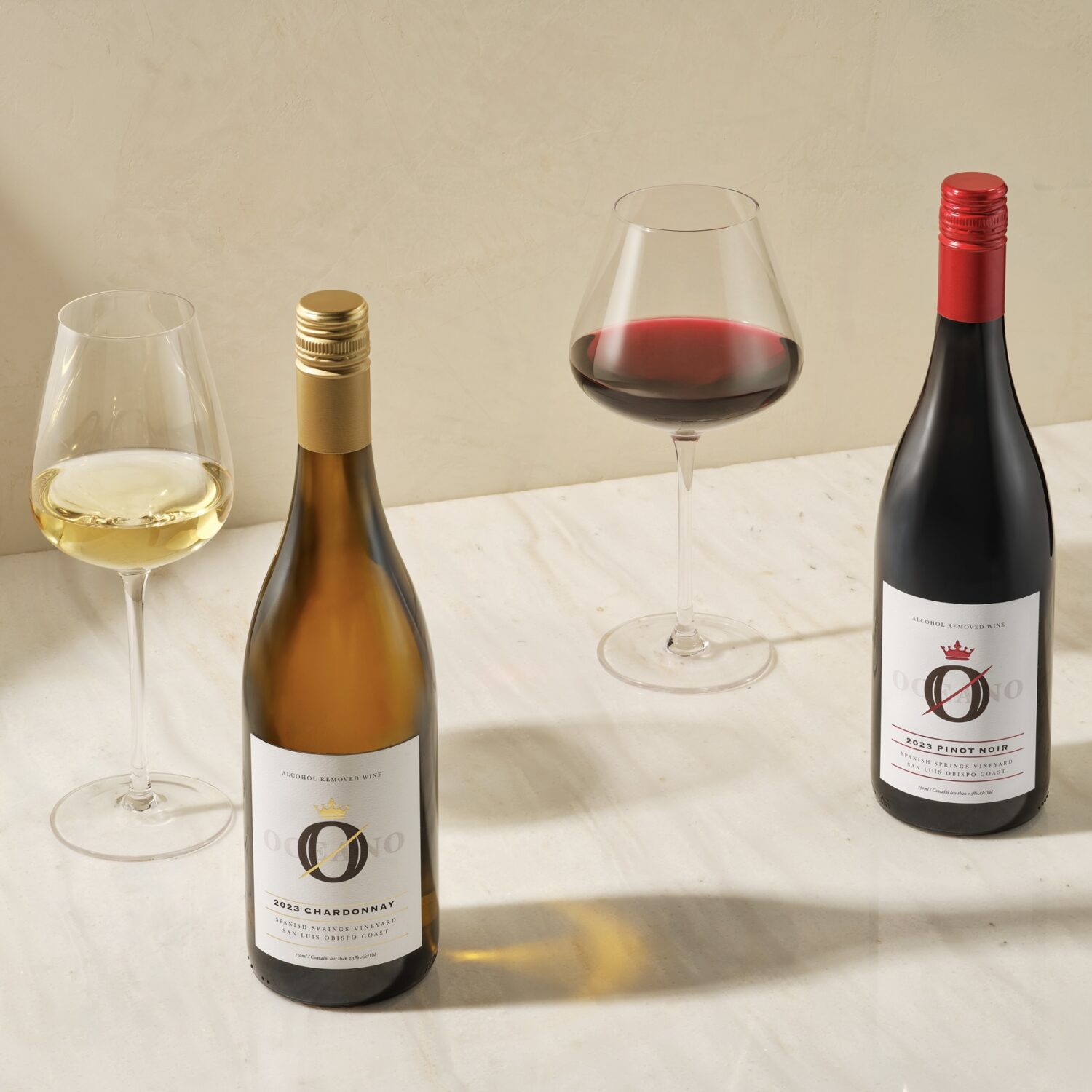 Two bottles of signature Oceano wine from their alcoholic wine pack sitting next to a poured glass of each.