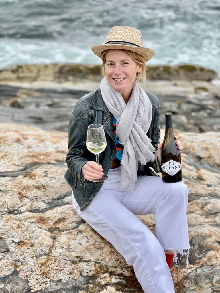 Portrait of Oceano Wines founder with a bottle of Chardonnay, reflecting fall rituals