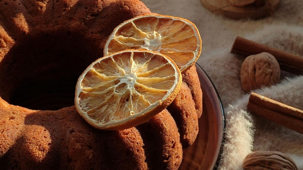 Citrus olive oil cake with fresh thyme next to a pour of nonalcoholic Chardonnay